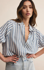 Load image into Gallery viewer, Woman wearing a blue and white striped shirt with a beige background
