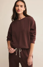 Load image into Gallery viewer, Woman wearing a brown crewneck sweatshirt and pants on a beige background
