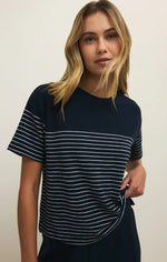 Load image into Gallery viewer, Woman wearing a navy blue and white striped t-shirt against a plain background
