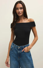 Load image into Gallery viewer, Woman wearing a black off-shoulder top and blue jeans against a plain background
