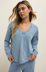Load image into Gallery viewer, Woman wearing a blue long-sleeve knit denim v-neck sweatshirt against a plain background
