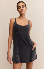 Load image into Gallery viewer, Woman wearing a black slip dress with front pockets against a beige background
