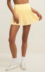 Load image into Gallery viewer, Person wearing a yellow pleated skirt on a beige background
