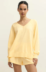 Load image into Gallery viewer, Woman wearing a yellow long-sleeve v neck sweatshirt and shorts on a beige background
