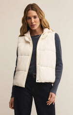Load image into Gallery viewer, Woman wearing a white puffer vest over a dark outfit on a plain background
