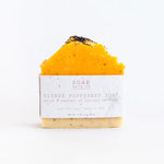 Load image into Gallery viewer, Citrus poppyseed soap bar with visible branding on a white background
