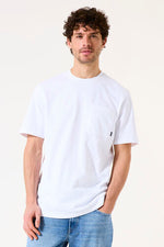Load image into Gallery viewer, Man wearing a white t-shirt with a small logo on a plain background
