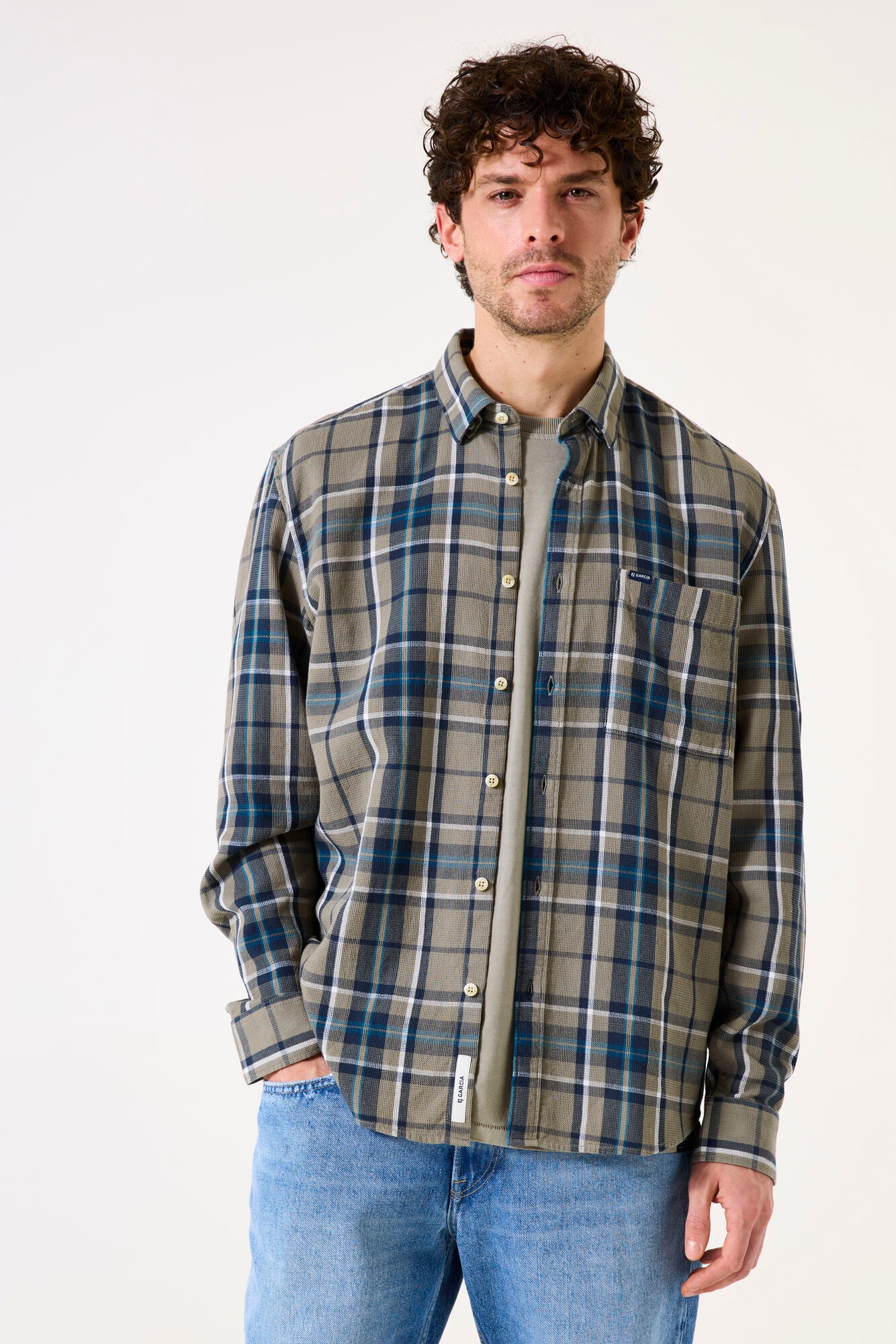 Man wearing a  green plaid button up shirt