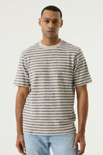 Load image into Gallery viewer, Man wearing a striped t-shirt and light blue jeans against a white background
