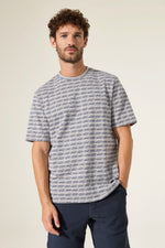 Load image into Gallery viewer, Man wearing a patterned gray and blue t-shirt against a plain background
