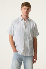 Load image into Gallery viewer, Man wearing a striped short-sleeve shirt and light blue jeans against a white background
