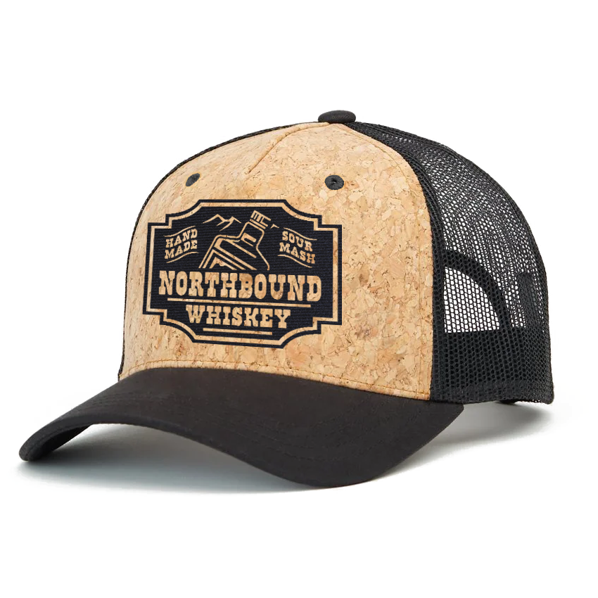 Cork and black trucker hat with 'Northbound Whiskey' branding on a white background