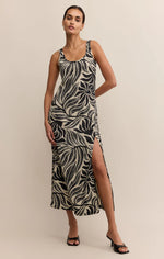 Load image into Gallery viewer, Woman wearing a black and white leaf pattern sleeveless midi dress. 

