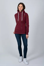 Load image into Gallery viewer, Woman wearing a burgundy sweatshirt with a high collar and blue jeans on a white background
