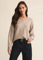 Load image into Gallery viewer, Woman wearing a beige  v neck sweater and dark jeans against a beige background
