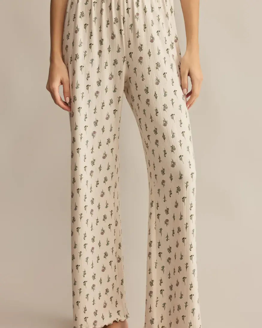 Beige pants with a subtle floral pattern on a plain background